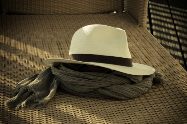 Chapeau posé sur un écharpe sur une chaise longue