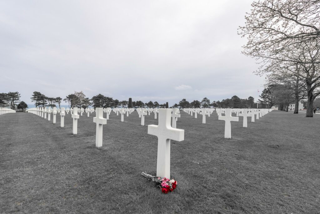 Tombe en couleur sur fond en noir et blanc au cimetière américain de Colleville-sur-Mer