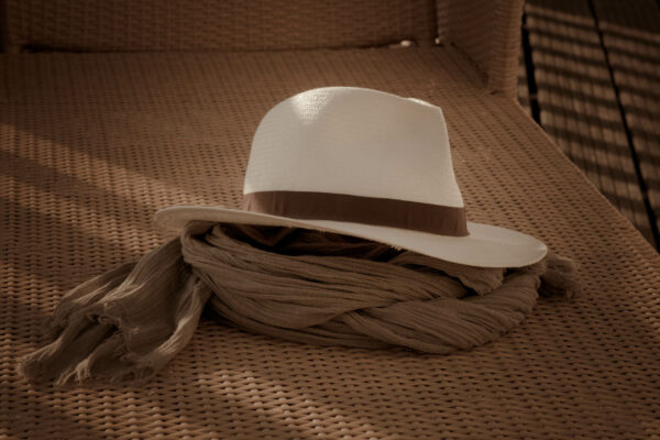 Chapeau posé sur un écharpe sur une chaise longue