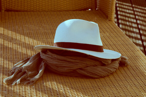 Chapeau posé sur un écharpe sur une chaise longue