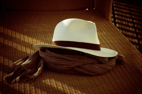 Chapeau posé sur un écharpe sur une chaise longue